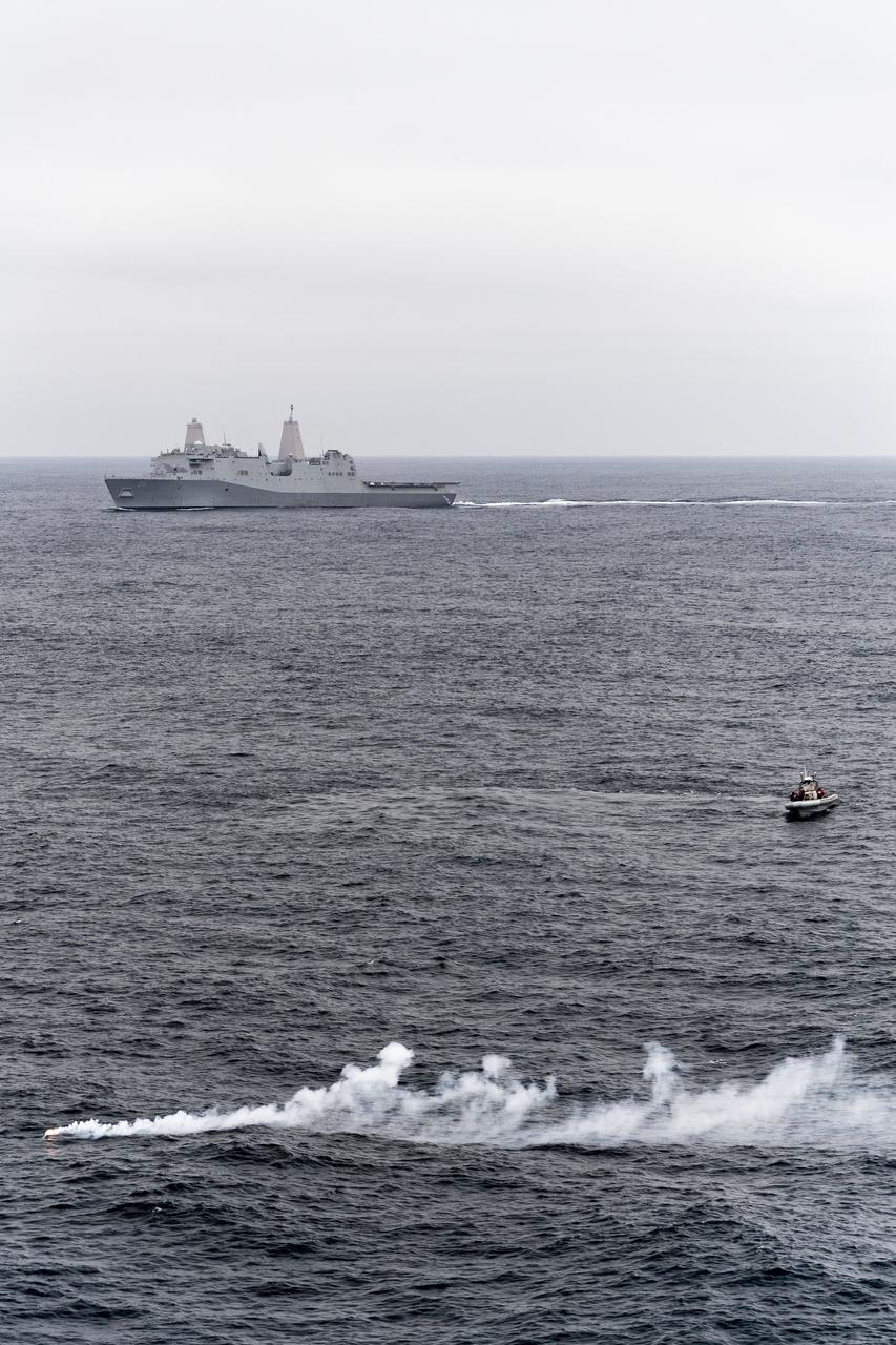 Small boats deployed from amphibious transport dock ship USS John P. Murtha (LPD 26) motor toward a smoke marker released by an MH-60S Seahawk helicopter to indicate the location of a mock Orion capsule during Underway Recovery Test 9 (URT-9). During the weeklong test, NASA’s Landing and Recovery Team conducted a full mission profile simulation to certify the team for Artemis I.