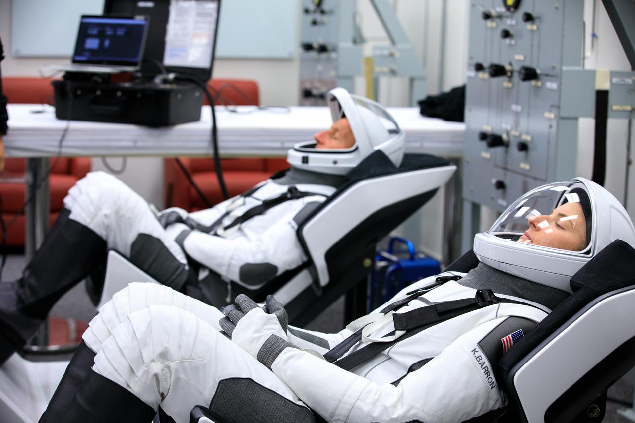 NASA SpaceX Crew-3 mission astronauts are in the suit-up room in the Astronaut Crew Quarters inside Kennedy Space Center’s Neil A. Armstrong Operations and Checkout Building on launch day, Nov. 10, 2021. A team of SpaceX suit technicians will help them as they put on their custom-fitted spacesuits and check the suits for leaks. In view, from left are NASA astronauts Tom Marshburn, pilot and Kayla Barron, mission specialist. The Falcon 9 rocket with Crew Dragon Endurance will launch the four-person crew to the International Space Station for NASA’s Commercial Crew Program. Crew-3 is scheduled to launch at 9:03 p.m. EST from Launch Complex 39A at Kennedy. 
