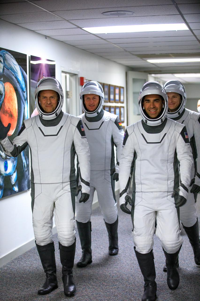 The SpaceX Crew-3 astronauts walk through the hallway in the Neil A. Armstrong Building’s Astronaut Crew Quarters at NASA’s Kennedy Space Center in Florida on Nov. 10, 2021. They will make their way to the customized Tesla Model X cars that will take them to their spacecraft at Launch Complex 39A. In front, from left are NASA astronauts Tom Marshburn, pilot, and Raja Chari, commander. Behind them, from left are Matthias Maurer, ESA (European Space Agency astronaut) and mission specialist; and NASA astronaut Kayla Barron, mission specialist. The Falcon 9 rocket with Crew Dragon Endurance will launch the four-person crew to the International Space Station for NASA’s Commercial Crew Program. Crew-3 is scheduled to launch at 9:03 p.m. EST from Launch Complex 39A at Kennedy.