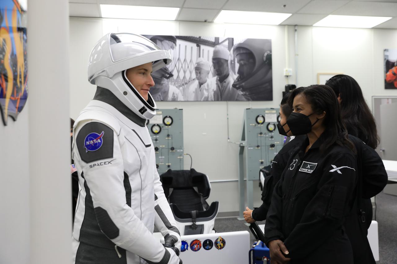 NASA SpaceX Crew-3 mission astronaut Kayla Barron talks with SpaceX suit technicians inside the suit-up room in the Astronaut Crew Quarters at Kennedy Space Center’s Neil A. Armstrong Operations and Checkout Building on launch day, Nov. 10, 2021. The Falcon 9 rocket with Crew Dragon Endurance will launch Barron and fellow NASA astronauts Raja Chari and Thomas Marshburn, along with ESA (European Space Agency) astronaut Matthias Maurer, to the International Space Station for NASA’s Commercial Crew Program. Crew-3 is scheduled to launch at 9:03 p.m. EST from Launch Complex 39A at Kennedy.