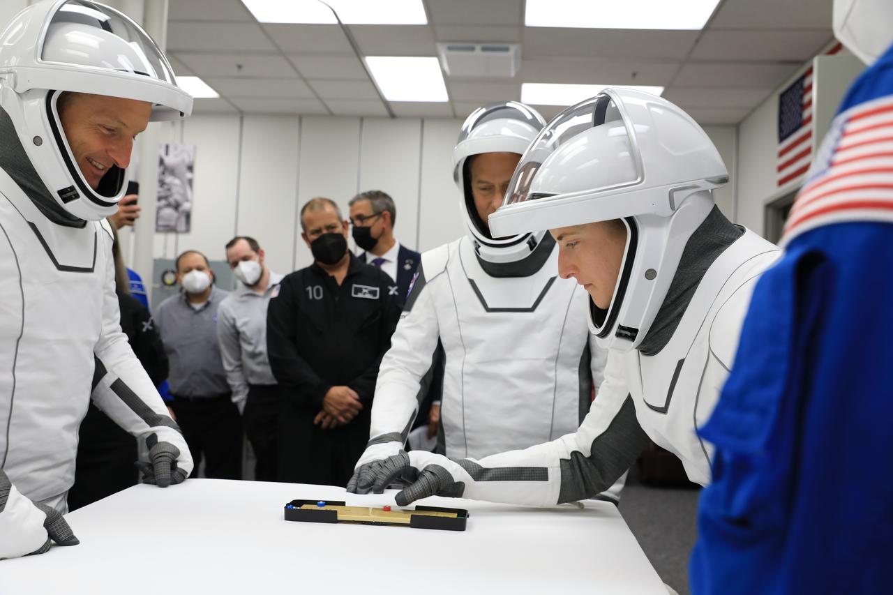 NASA SpaceX Crew-3 mission astronauts Matthias Maurer, left, and Kayla Barron, play a game inside the suit-up room in the Astronaut Crew Quarters at Kennedy Space Center’s Neil A. Armstrong Operations and Checkout Building on launch day, Nov. 10, 2021. The Falcon 9 rocket with Crew Dragon Endurance will launch Maurer and Barron, along with fellow Crew-3 astronauts Raja Chari and Thomas Marshburn to the International Space Station for NASA’s Commercial Crew Program. Crew-3 is scheduled to launch at 9:03 p.m. EST from Launch Complex 39A at Kennedy.