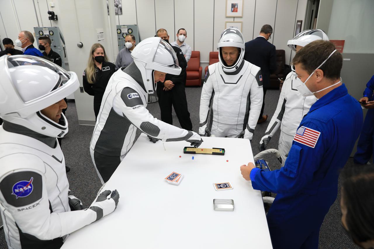 NASA SpaceX Crew-3 mission astronauts play a game while inside the suit-up room in the Astronaut Crew Quarters at Kennedy Space Center’s Neil A. Armstrong Operations and Checkout Building on launch day, Nov. 10, 2021. The Falcon 9 rocket with Crew Dragon Endurance will launch Crew-3 astronauts Raja Chari, Thomas Marshburn, Kayla Barron and Matthias Maurer to the International Space Station for NASA’s Commercial Crew Program. Crew-3 is scheduled to launch at 9:03 p.m. EST from Launch Complex 39A at Kennedy.