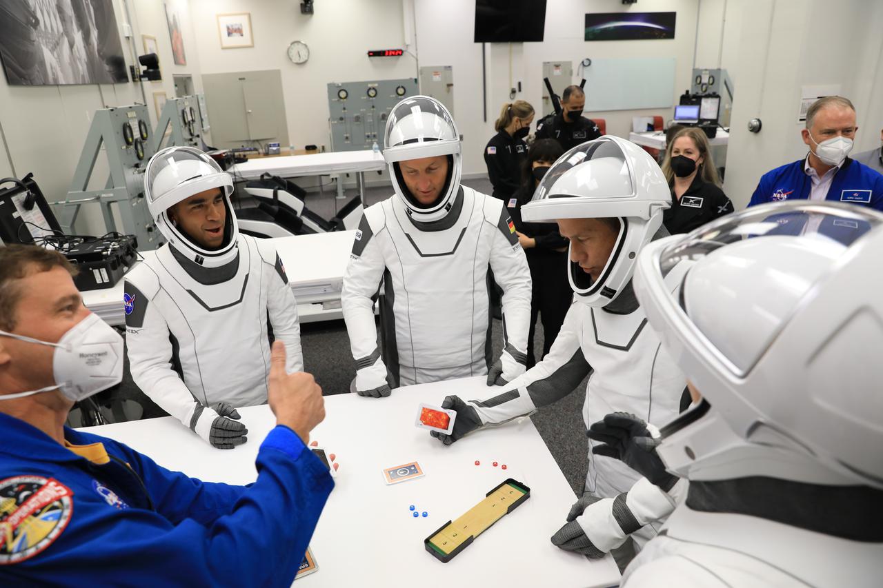 NASA SpaceX Crew-3 mission astronauts play a game while inside the suit-up room in the Astronaut Crew Quarters at Kennedy Space Center’s Neil A. Armstrong Operations and Checkout Building on launch day, Nov. 10, 2021. The Falcon 9 rocket with Crew Dragon Endurance will launch Crew-3 astronauts Raja Chari, Thomas Marshburn, Kayla Barron and Matthias Maurer to the International Space Station for NASA’s Commercial Crew Program. Crew-3 is scheduled to launch at 9:03 p.m. EST from Launch Complex 39A at Kennedy.