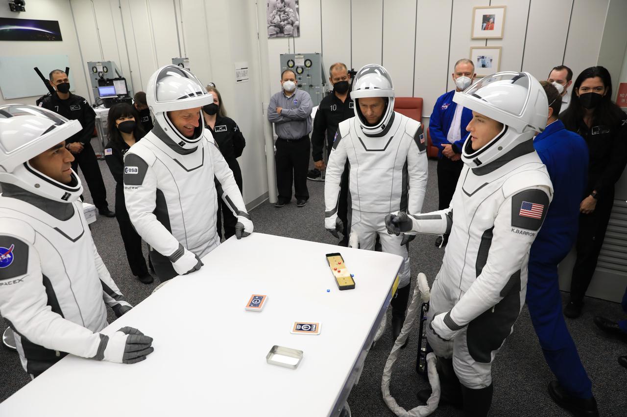 NASA SpaceX Crew-3 mission astronauts play a game while inside the suit-up room in the Astronaut Crew Quarters at Kennedy Space Center’s Neil A. Armstrong Operations and Checkout Building on launch day, Nov. 10, 2021. The Falcon 9 rocket with Crew Dragon Endurance will launch Crew-3 astronauts Raja Chari, Thomas Marshburn, Kayla Barron and Matthias Maurer to the International Space Station for NASA’s Commercial Crew Program. Crew-3 is scheduled to launch at 9:03 p.m. EST from Launch Complex 39A at Kennedy.