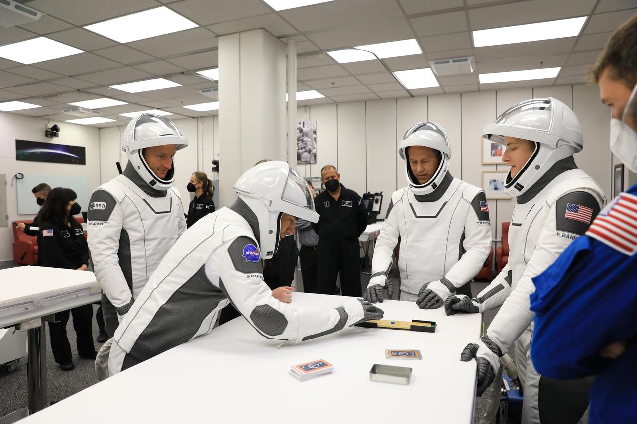 NASA SpaceX Crew-3 mission astronauts play a game while inside the suit-up room in the Astronaut Crew Quarters at Kennedy Space Center’s Neil A. Armstrong Operations and Checkout Building on launch day, Nov. 10, 2021. The Falcon 9 rocket with Crew Dragon Endurance will launch Crew-3 astronauts Raja Chari, Thomas Marshburn, Kayla Barron and Matthias Maurer to the International Space Station for NASA’s Commercial Crew Program. Crew-3 is scheduled to launch at 9:03 p.m. EST from Launch Complex 39A at Kennedy.
