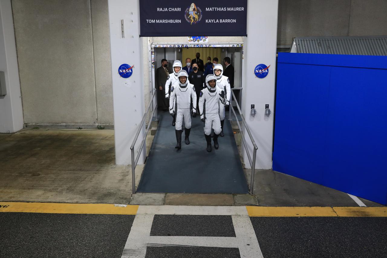 The SpaceX Crew-3 astronauts walk out through the double doors below the Neil A. Armstrong Building’s Astronaut Crew Quarters at NASA’s Kennedy Space Center in Florida on Nov. 10, 2021. They will make their way to the customized Tesla Model X cars that will take them to their spacecraft at Launch Complex 39A. In front, from left, are NASA astronauts Tom Marshburn, pilot, and Raja Chari, commander. Behind them, from left, are Matthias Maurer, ESA (European Space Agency astronaut) and mission specialist; and NASA astronaut Kayla Barron, mission specialist. The Falcon 9 rocket with Crew Dragon Endurance will launch the four-person crew to the International Space Station for NASA’s Commercial Crew Program. Crew-3 is scheduled to launch at 9:03 p.m. EST from Launch Complex 39A at Kennedy.