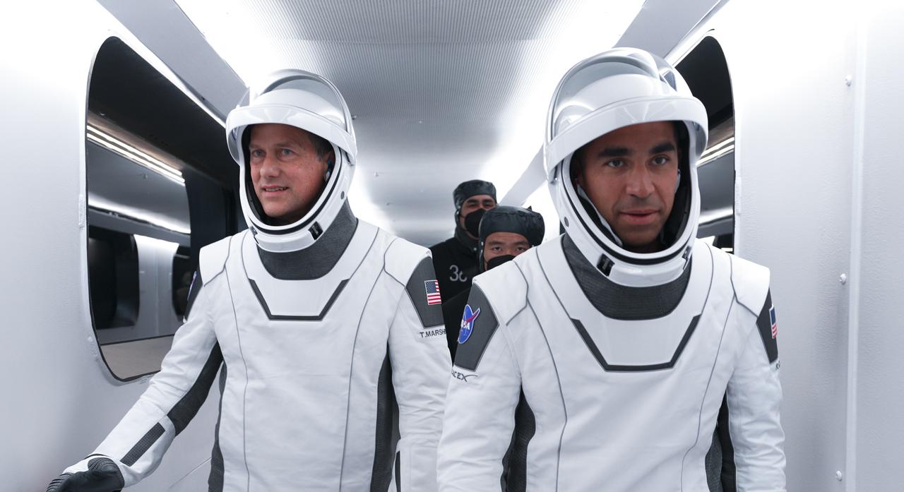 The SpaceX Crew-3 astronauts walk across the crew access arm to the Crew Dragon atop the SpaceX Falcon 9 rocket at Launch Complex 39A at NASA’s Kennedy Space Center in Florida on Nov. 10, 2021. In view from left are NASA astronauts Tom Marshburn, pilot, and Raja Chari, commander. The Falcon 9 rocket with Crew Dragon Endurance will launch the four-person crew to the International Space Station for the agency’s Commercial Crew Program. Crew-3 is scheduled to launch at 9:03 p.m. EST from historic Launch Pad 39A at Kennedy. 