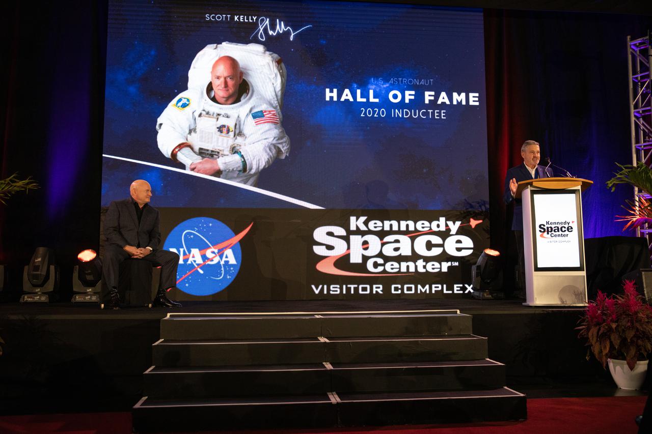 Scott Kelly (left) is one of three former astronauts inducted into the U.S. Astronaut Hall of Fame (AHOF) on Nov. 13, 2021, during a ceremony at the Kennedy Space Center Visitor Complex in Florida. NASA Associate Administrator Robert Cabana (at podium), former NASA astronaut and Hall of Famer, inducted Kelly, who received an official medal and became a member of the 19th class of space shuttle astronauts to be inducted. The 2021 inductees were selected by a committee of Hall of Fame astronauts, former NASA officials, flight directors, historians, and journalists. This year’s induction brings the total number of AHOF members to 102.