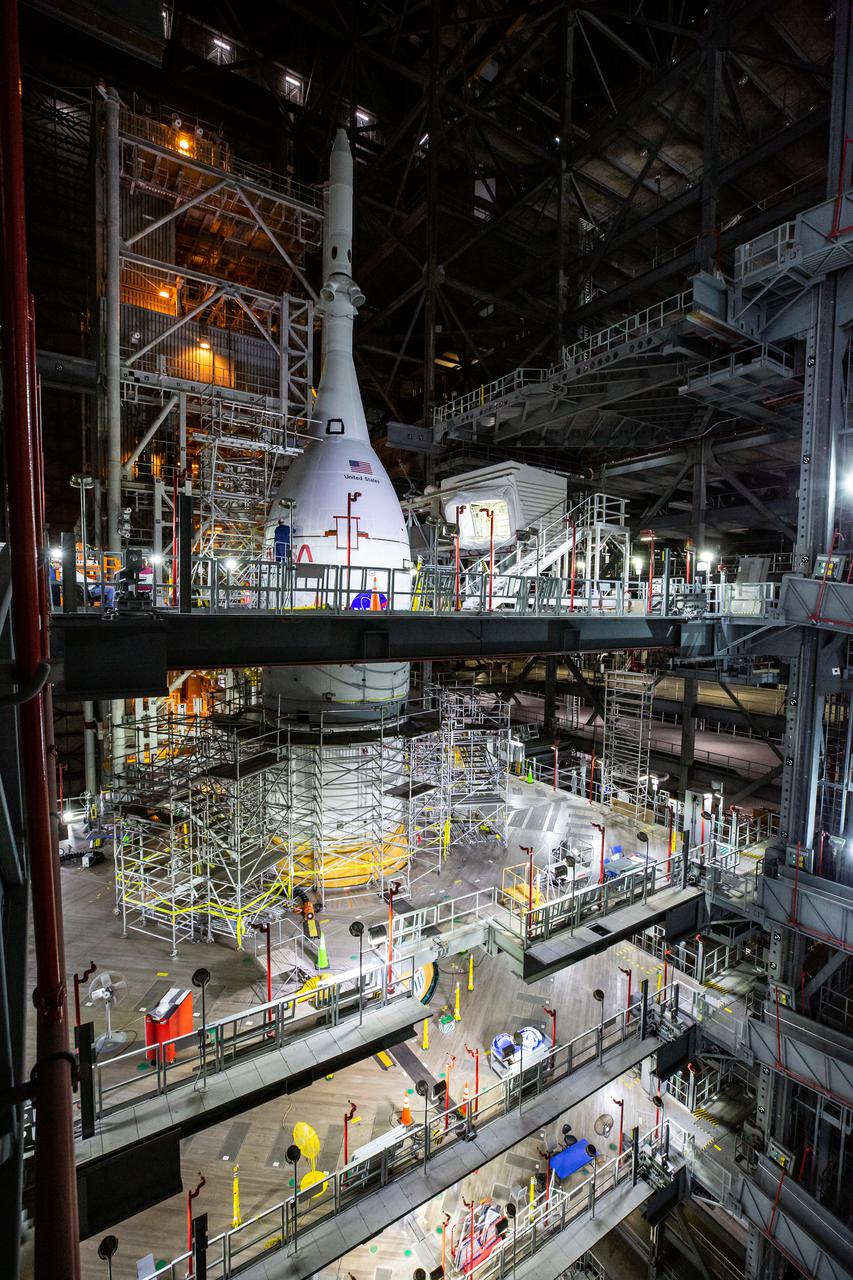 The Artemis I Orion spacecraft, secured on the Space Launch System (SLS) and enclosed in its launch abort system, is in view high up in High Bay 3 of the Vehicle Assembly Building at NASA’s Kennedy Space Center in Florida on Jan. 10, 2022. Work platforms are extended around Orion and scaffolding has been secured to allow access for inspection and processing work. Artemis I will be the first integrated test of NASA’s deep space exploration systems: the Orion spacecraft, Space Launch System (SLS) rocket and the ground systems at Kennedy. In later missions, NASA will land the first woman and the first person of color on the surface of the Moon, paving the way for a long-term lunar presence and serving as a steppingstone on the way to Mars. 