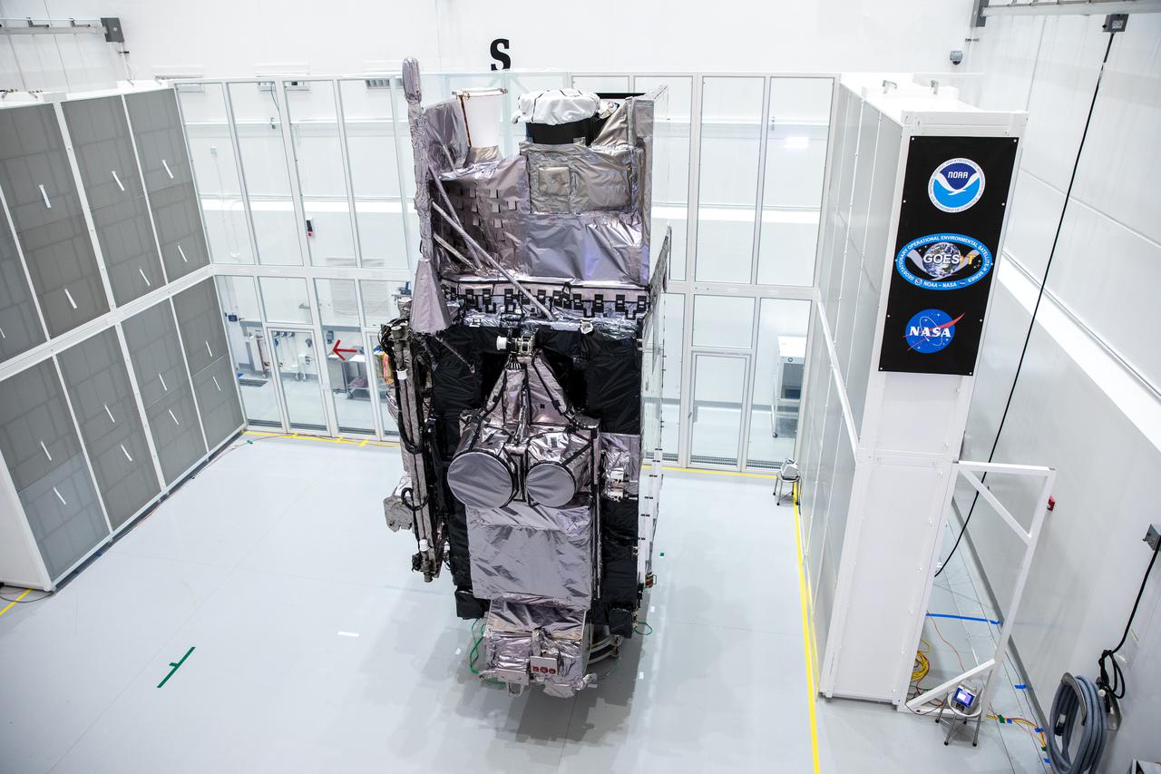 NOAA’s Geostationary Operational Environmental Satellite-T (GOES-T) is in view alongside its banner inside the Astrotech Space Operations facility in Titusville, Florida, on Jan. 20, 2022. GOES-T is scheduled to launch on March 1, 2022, atop a United Launch Alliance (ULA) Atlas V 541 rocket from Space Launch Complex 41 at Cape Canaveral Space Force Station. GOES-T is the third satellite in the GOES-R series that will continue to help meteorologists observe and predict local weather events that affect public safety. The launch is being managed by NASA’s Launch Services Program based at Kennedy Space Center in Florida, America’s multi-user spaceport. 