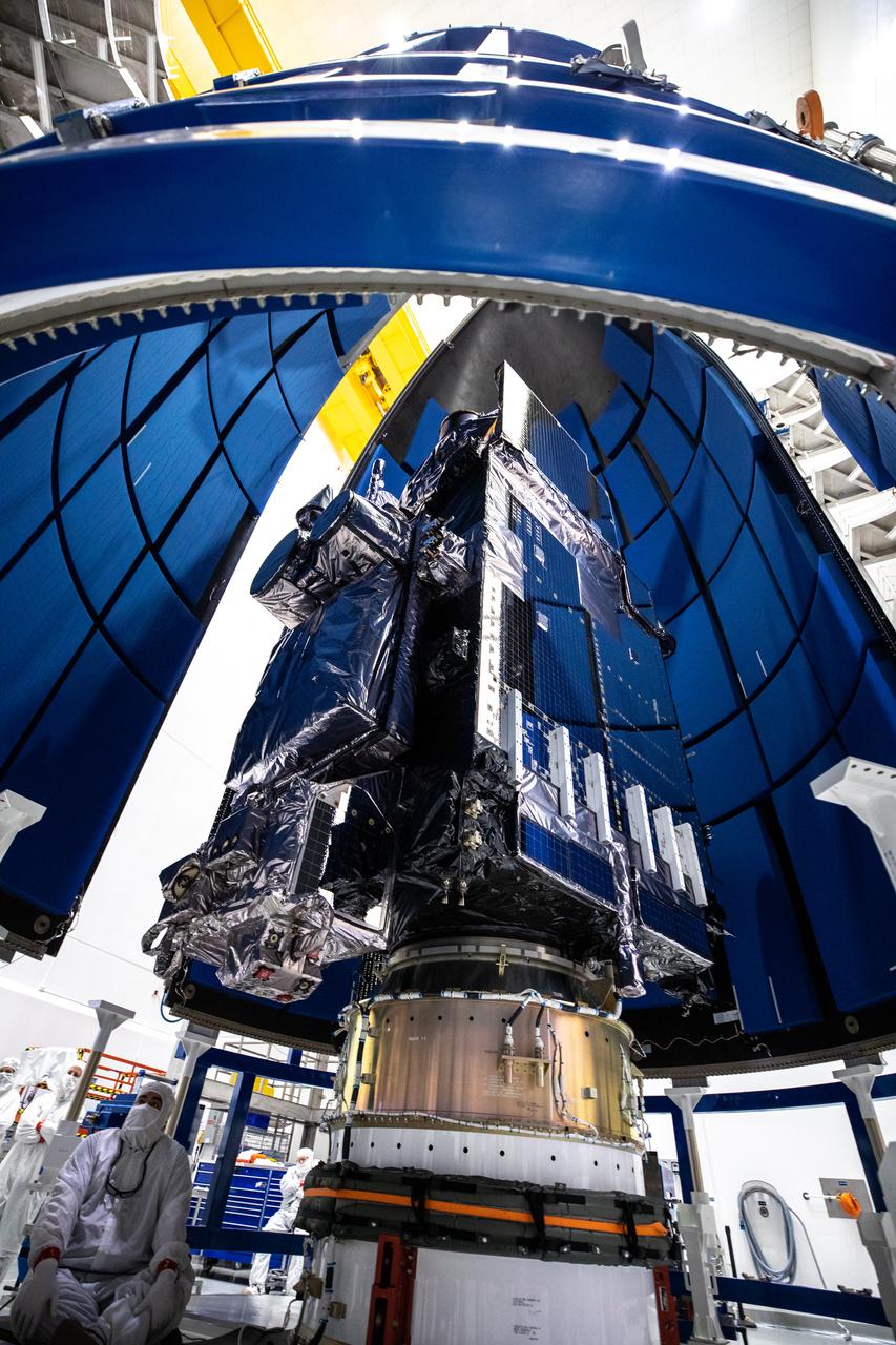 In this view looking up, the United Launch Alliance Atlas V payload fairings are being secured around NOAA’s Geostationary Operational Environmental Satellite-T (GOES-T) inside the Astrotech Space Operations facility in Titusville, Florida, on Feb. 7, 2022. The payload fairings will secure and protect the satellite during launch. GOES-T is scheduled to launch on March 1, 2022, atop the Atlas V 541 rocket from Space Launch Complex 41 at Cape Canaveral Space Force Station. GOES-T is the third satellite in the GOES-R series that will continue to help meteorologists observe and predict local weather events that affect public safety. The launch is being managed by NASA’s Launch Services Program based at Kennedy Space Center in Florida, America’s multi-user spaceport. 