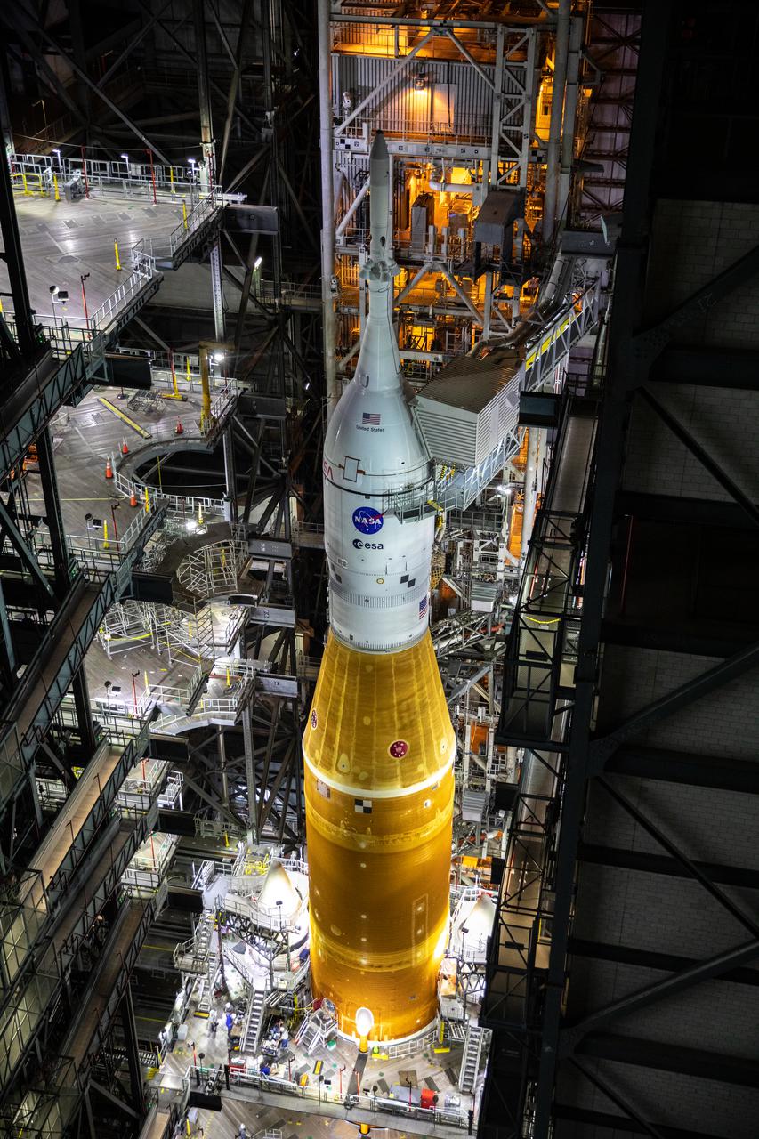In this view looking down inside the Vehicle Assembly Building at NASA’s Kennedy Space Center in Florida on March 10, 2022, the work platforms are being retracted from around the Artemis I Space Launch System rocket and Orion spacecraft in preparation to roll out to launch pad 39B. The Kennedy ground systems team is working to remove equipment and scaffolding away from the rocket and will continue retracting the platforms until the entire rocket is revealed ahead of the wet dress rehearsal test, which is scheduled to occur approximately two weeks after it arrives at the pad.