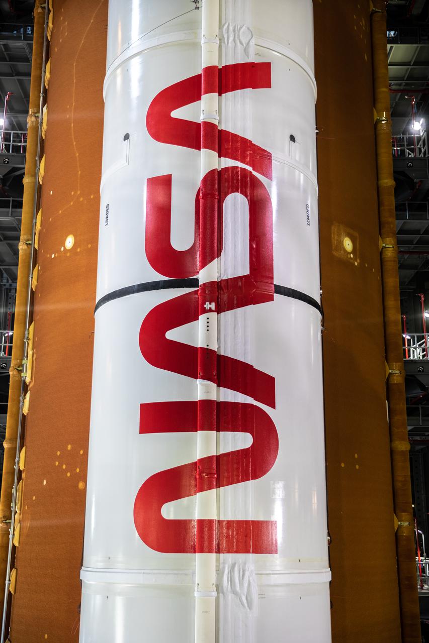 Inside High Bay 3 of the Vehicle Assembly Building at NASA’s Kennedy Space Center in Florida, application of the NASA worm logo is complete on the first of two solid rocket boosters for the Artemis I Space Launch System on March 14, 2022. The SLS and Orion spacecraft are stacked in the high bay and ready for rollout to Launch Complex 39B for a wet dress rehearsal. Artemis I will be the first integrated test of the SLS and Orion spacecraft. In later missions, NASA will land the first woman and the first person of color on the surface of the Moon, paving the way for a long-term lunar presence and serving as a steppingstone on the way to Mars.