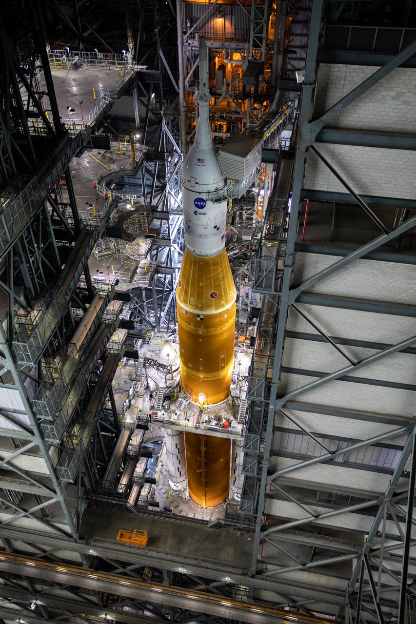 In this view looking down inside the Vehicle Assembly Building at NASA’s Kennedy Space Center in Florida on March 14, 2022, most of the work platforms have been retracted from around the Artemis I Space Launch System rocket and Orion spacecraft in preparation to roll out to launch pad 39B. The Kennedy ground systems team is working to remove equipment and scaffolding away from the rocket and will continue retracting the platforms until the entire rocket is revealed ahead of the wet dress rehearsal test, which is scheduled to occur approximately two weeks after it arrives to 39B. Artemis I is the first in a series of increasingly complex missions that will enable human exploration to the Moon and Mars.