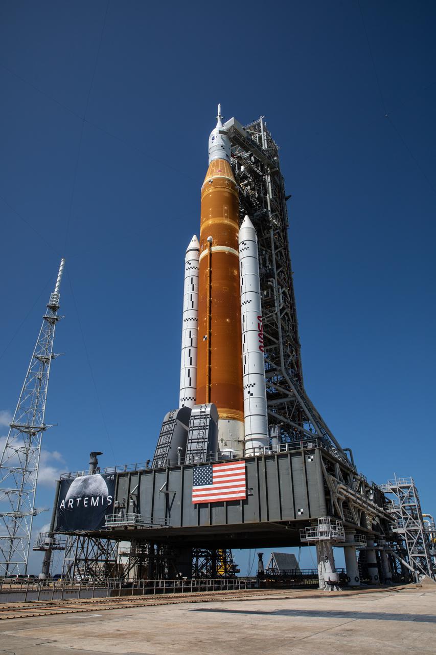 Standing atop the mobile launcher, NASA’s Space Launch System (SLS) rocket is photographed at Launch Pad 39B at the agency’s Kennedy Space Center in Florida on March 18, 2022. The rocket, with the Orion capsule atop, was carried from the Vehicle Assembly Building to the pad – a 4.2-mile journey that took nearly 11 hours to complete – by the agency’s crawler-transporter 2 for a wet dress rehearsal ahead of the uncrewed Artemis I launch. Artemis I will test SLS and Orion as an integrated system prior to crewed flights to the Moon. Through Artemis, NASA will land the first woman and the first person of color on the lunar surface, paving the way for a long-term lunar presence and serving as a steppingstone on the way to Mars.