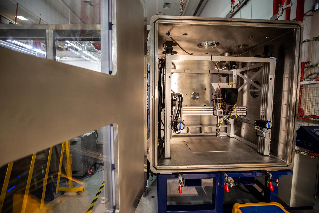 A team of engineers and researchers prepares a vacuum chamber in the Granular Mechanics and Regolith Operations (GMRO) lab inside NASA Kennedy Space Center’s Swamp Works for testing 3D printing, as part of the Relevant Environment Additive Construction Technology (REACT) project at the Florida spaceport on April 5, 2022. The project derives from NASA’s 2020 Announcement of Collaboration Opportunity, with AI SpaceFactory – an architectural and construction technology company and winner of NASA’s 3D Printed Habitat Challenge – collaborating with Kennedy teams to build 3D-printed test structures using a composite made from polymers and a regolith simulant in a vacuum chamber that mimics environmental conditions on the Moon. 