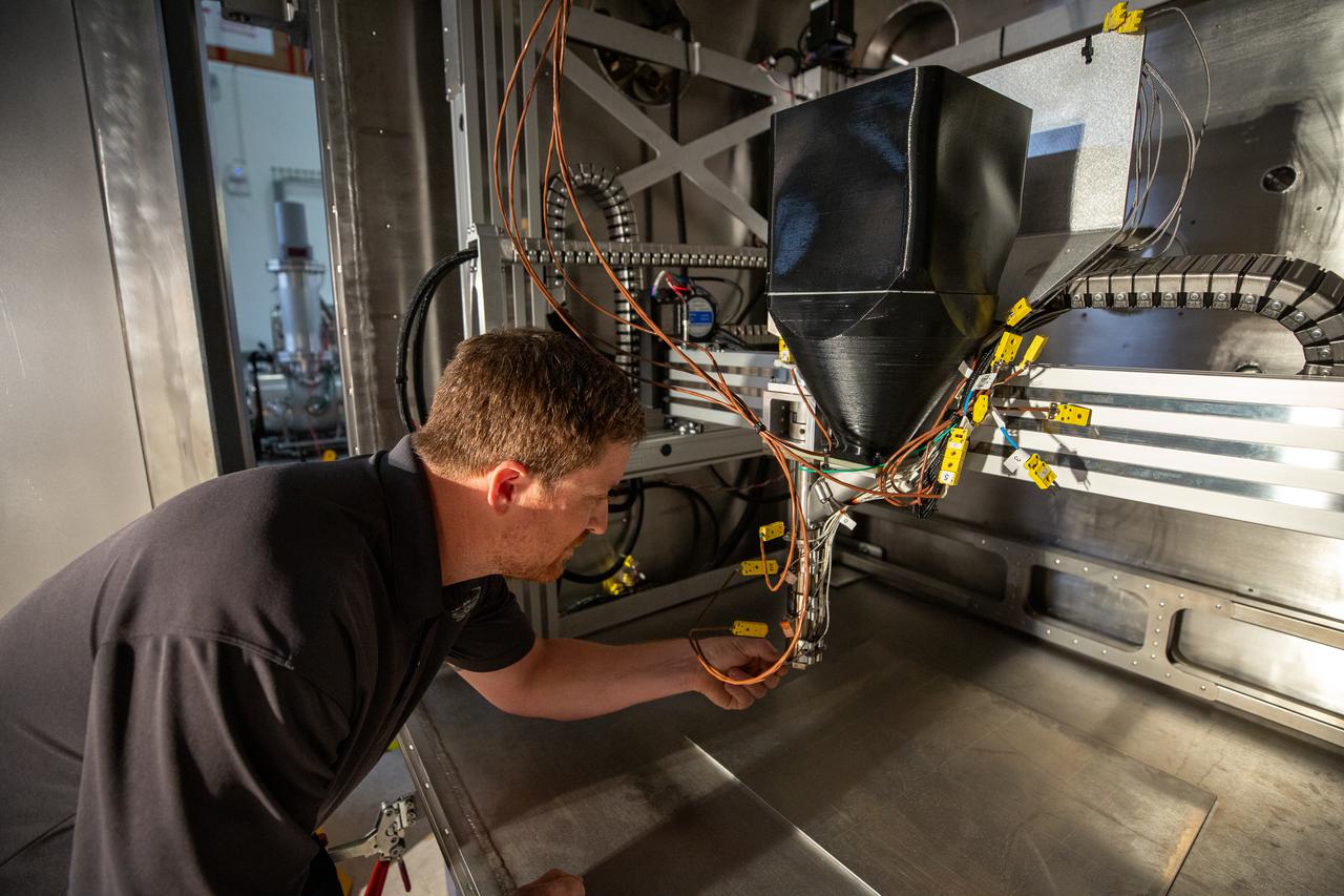 Nathan Gelino, a principal investigator with the Exploration Research and Technology programs at Kennedy Space Center in Florida, prepares a vacuum chamber for testing 3D printing inside the Granular Mechanics and Regolith Operations (GMRO) lab at Kennedy’s Swamp Works on April 5, 2022. The testing is part of the Relevant Environment Additive Construction Technology (REACT) project, which derives from NASA’s 2020 Announcement of Collaboration Opportunity, with AI SpaceFactory – an architectural and construction technology company and winner of NASA’s 3D Printed Habitat Challenge – collaborating with Kennedy teams to build 3D-printed test structures using a composite made from polymers and a regolith simulant in a vacuum chamber that mimics environmental conditions on the Moon. 