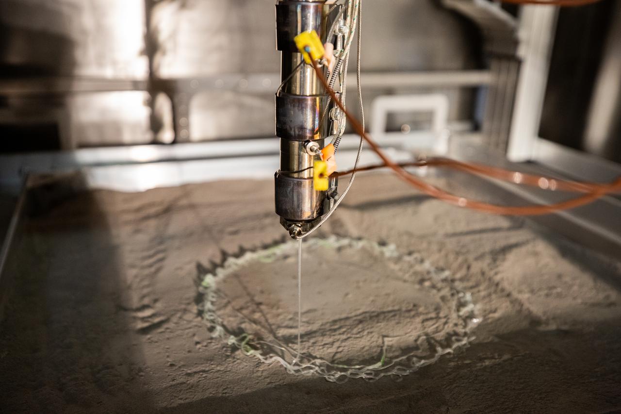 A team at NASA’s Kennedy Space Center in Florida test a 3D printer inside a vacuum chamber at the Granular Mechanics and Regolith Operations (GMRO) lab inside the spaceport’s Swamp Works, as part of the Relevant Environment Additive Construction Technology (REACT) project on April 5, 2022. Testing REACT derives from NASA’s 2020 Announcement of Collaboration Opportunity, with AI SpaceFactory – an architectural and construction technology company and winner of NASA’s 3D Printed Habitat Challenge – collaborating with Kennedy teams to build 3D-printed test structures using a composite made from polymers and a regolith simulant in a vacuum chamber that mimics environmental conditions on the Moon. 