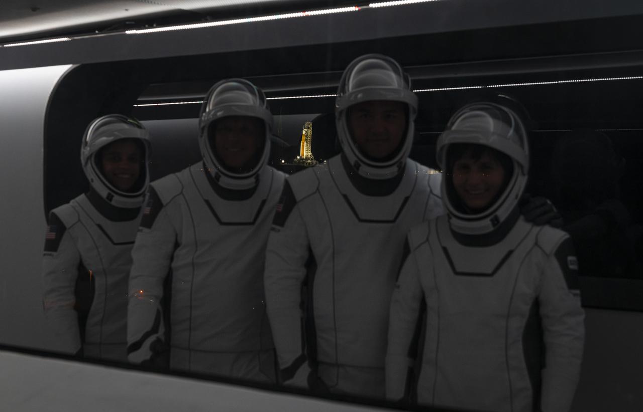 Crew-4 astronauts, from left, Jessica Watkins, Bob Hines, Kjell Lindgren, and Samantha Cristoforetti stand inside the crew access arm at Kennedy Space Center’s Launch Complex 39A during a dry dress rehearsal on April 20, 2022. Reflected and lit up in the background is NASA’s Space Launch System rocket and Orion spacecraft for the Artemis I mission at Launch Complex 39B. SpaceX’s Falcon 9 rocket, with the company’s Crew Dragon, named Freedom by the Crew-4 crew, is targeted for liftoff no earlier than 4:15 a.m. EDT on Tuesday, April 26, 2022, from Pad 39A. The Crew-4 mission will carry the astronauts to the International Space Station as part of NASA’s Commercial Crew Program.