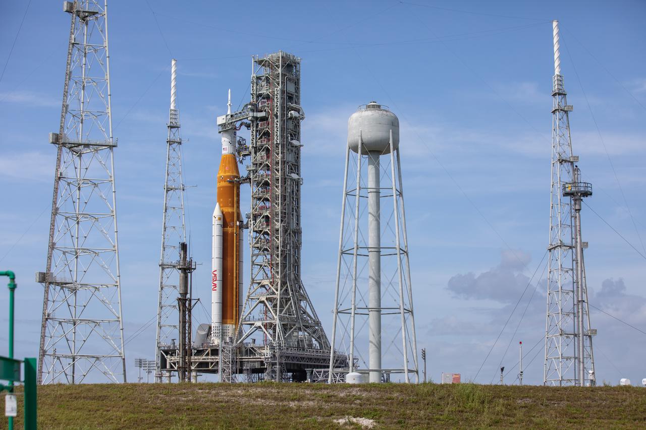 A view of the Artemis I Space Launch System (SLS) and Orion spacecraft on Launch Pad 39B at NASA’s Kennedy Space Center in Florida on April 21, 2022. Also in view are the three lightning protection towers and water tower. The SLS and Orion atop the mobile launcher were transported to the pad on crawler-transporter 2 for a prelaunch test called a wet dress rehearsal. Artemis I will be the first integrated test of the SLS and Orion spacecraft. In future Artemis missions, NASA will land the first woman and the first person of color on the surface of the Moon, paving the way for a long-term lunar presence and serving as a steppingstone on the way to Mars.