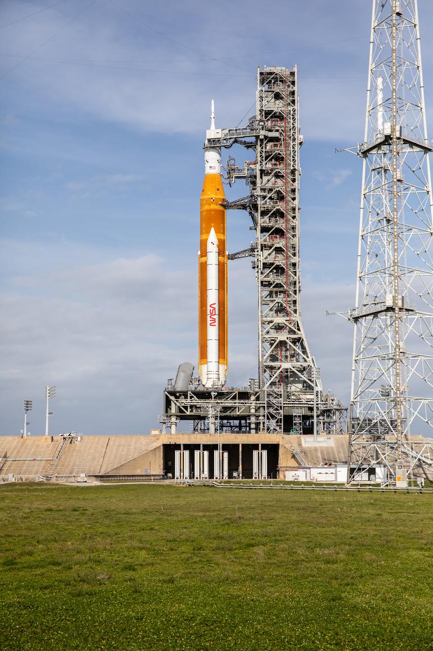 A view of the Artemis I Space Launch System (SLS) and Orion spacecraft on Launch Pad 39B at NASA’s Kennedy Space Center in Florida on April 21, 2022. Also in view is one of three lightning protection towers. The SLS and Orion atop the mobile launcher were transported to the pad on crawler-transporter 2 for a prelaunch test called a wet dress rehearsal. Artemis I will be the first integrated test of the SLS and Orion spacecraft. In future Artemis missions, NASA will land the first woman and the first person of color on the surface of the Moon, paving the way for a long-term lunar presence and serving as a steppingstone on the way to Mars.