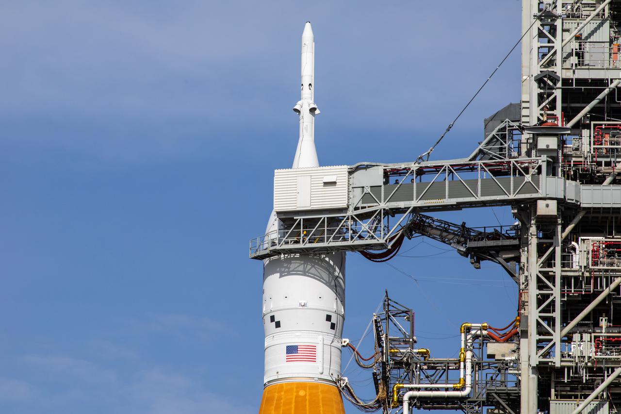 A close-up view of the Artemis I Orion spacecraft, secured inside the Launch Abort System atop the Space Launch System (SLS) on Launch Pad 39B at NASA’s Kennedy Space Center in Florida on April 21, 2022. A portion of the mobile launcher and the crew access arm also is in view. The SLS and Orion atop the mobile launcher were transported to the pad on crawler-transporter 2 for a prelaunch test called a wet dress rehearsal. Artemis I will be the first integrated test of the SLS and Orion spacecraft. In future Artemis missions, NASA will land the first woman and the first person of color on the surface of the Moon, paving the way for a long-term lunar presence and serving as a steppingstone on the way to Mars.