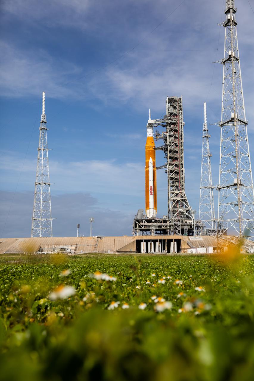 A view of the Artemis I Space Launch System (SLS) and Orion spacecraft atop the mobile launcher on Launch Pad 39B at NASA’s Kennedy Space Center in Florida on April 21, 2022. Also in view are the three lightning protection towers. The SLS and Orion atop the mobile launcher were transported to the pad on crawler-transporter 2 for a prelaunch test called a wet dress rehearsal. Artemis I will be the first integrated test of the SLS and Orion spacecraft. In future Artemis missions, NASA will land the first woman and the first person of color on the surface of the Moon, paving the way for a long-term lunar presence and serving as a steppingstone on the way to Mars.
