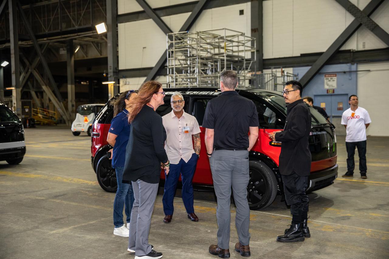 Artemis I Launch Director Charlie Blackwell Thompson, facing away from the camera, talks with Anthony Aquila, chief executive officer of Canoo Technologies Inc., inside the Vehicle Assembly Building at NASA’s Kennedy Space Center in Florida on May 11, 2022. Canoo Technologies Inc., was awarded a contract to design and provide the next generation of CTVs for the Artemis crewed missions. Representatives with Canoo were at the spaceport demonstrating the environmentally friendly fleet of vehicles. Artemis II will be the first Artemis mission flying crew aboard Orion. In later missions, NASA will land the first woman and the first person of color on the surface of the Moon, paving the way for a long-term lunar presence and serving as a steppingstone on the way to Mars. P