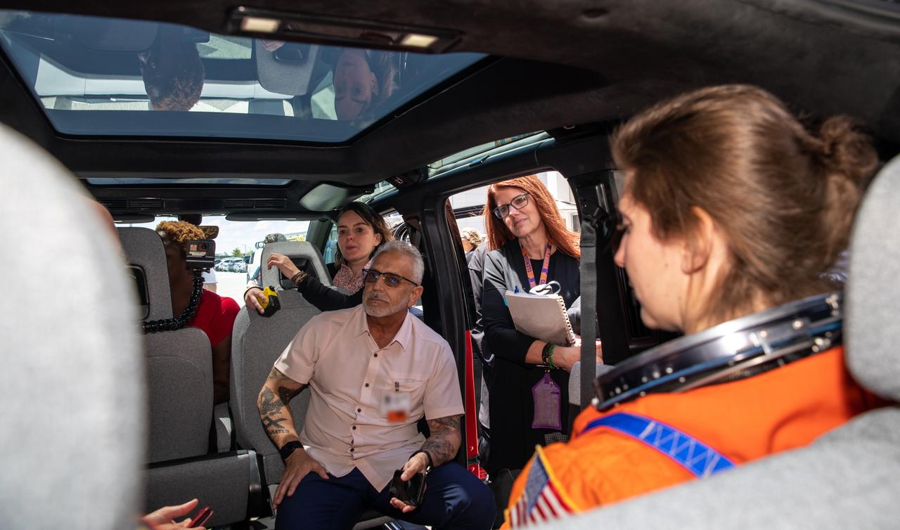 Technicians from Johnson Space Center, dressed in flight suits, secure themselves inside a prototype of a crew transportation vehicle (CTV) for Artemis crewed missions for a test drive near the Neil Armstrong Operations and Checkout Building at NASA’s Kennedy Space Center in Florida on May 11, 2022. Canoo Technologies Inc., was awarded a contract to design and provide the next generation of CTVs for the Artemis crewed missions Representatives with Canoo were at the spaceport demonstrating the environmentally friendly fleet of vehicles. Also in view near the vehicle’s door is Artemis I Launch Director Charlie Blackwell Thompson, and at left, is Anthony Aquila, chief executive officer of Canoo Technologies Inc.. Artemis II will be the first Artemis mission flying crew aboard Orion. In later missions, NASA will land the first woman and the first person of color on the surface of the Moon, paving the way for a long-term lunar presence and serving as a steppingstone on the way to Mars.