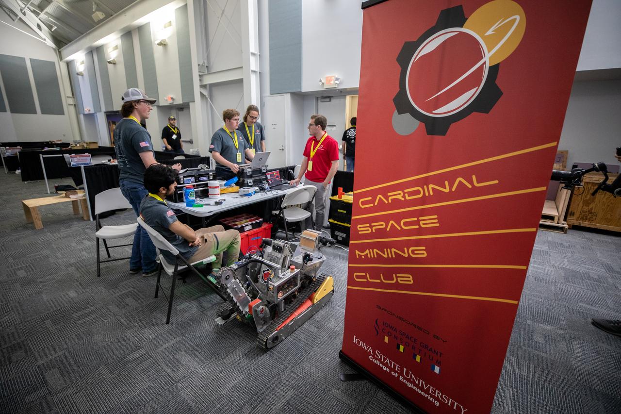 Students from Iowa State University College students prepare their robotic miner for its turn to dig in the mining arena during NASA’s LUNABOTICS competition on May 23, 2022, at the Center for Space Education near the Kennedy Space Center Visitor Complex in Florida. More than 35 teams from around the U.S. have designed and built remote-controlled robots for the mining competition. Teams use their autonomous or remote-controlled robots to maneuver and dig in a supersized sandbox filled with rocks and simulated lunar soil, or regolith. The objective of the challenge is to see which team’s robot can collect and deposit the most rocky regolith within a specified amount of time. 