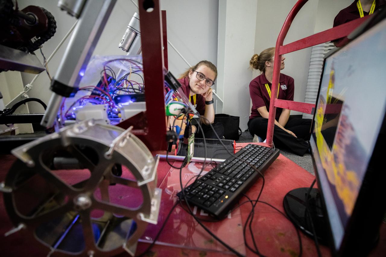 Students with Florida Technological University prepare their robotic miner for its turn to dig in the mining arena during NASA’s LUNABOTICS competition on May 23, 2022, at the Center for Space Education near the Kennedy Space Center Visitor Complex in Florida. More than 35 teams from around the U.S. have designed and built remote-controlled robots for the mining competition. Teams use their autonomous or remote-controlled robots to maneuver and dig in a supersized sandbox filled with rocks and simulated lunar soil, or regolith. The objective of the challenge is to see which team’s robot can collect and deposit the most rocky regolith within a specified amount of time. 