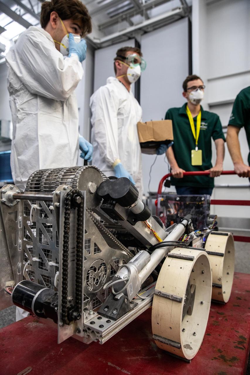 Students from Colorado State University prepare their robotic miner for its turn to dig in the mining arena during NASA’s LUNABOTICS competition on May 24, 2022, at the Center for Space Education near the Kennedy Space Center Visitor Complex in Florida. More than 35 teams from around the U.S. have designed and built remote-controlled robots for the mining competition. Teams use their autonomous or remote-controlled robots to maneuver and dig in a supersized sandbox filled with rocks and simulated lunar soil, or regolith. The objective of the challenge is to see which team’s robot can collect and deposit the most rocky regolith within a specified amount of time. 