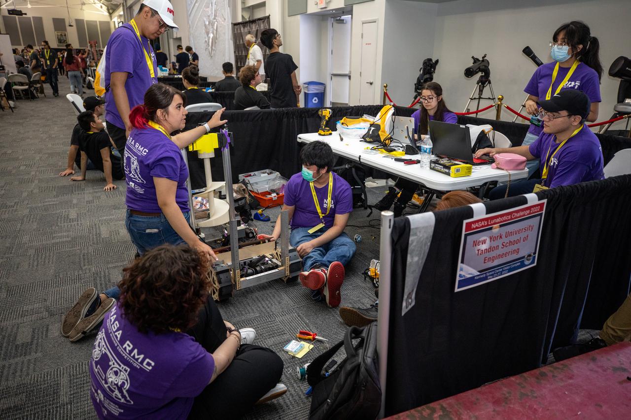 Students from the New York University Tandon School of Engineering prepare their robot for its turn to dig in the mining arena during NASA’s LUNABOTICS competition on May 24, 2022, at the Center for Space Education near the Kennedy Space Center Visitor Complex in Florida. More than 35 teams from around the U.S. have designed and built remote-controlled robots for the mining competition. Teams use their autonomous or remote-controlled robots to maneuver and dig in a supersized sandbox filled with rocks and simulated lunar soil, or regolith. The objective of the challenge is to see which team’s robot can collect and deposit the most rocky regolith within a specified amount of time.
