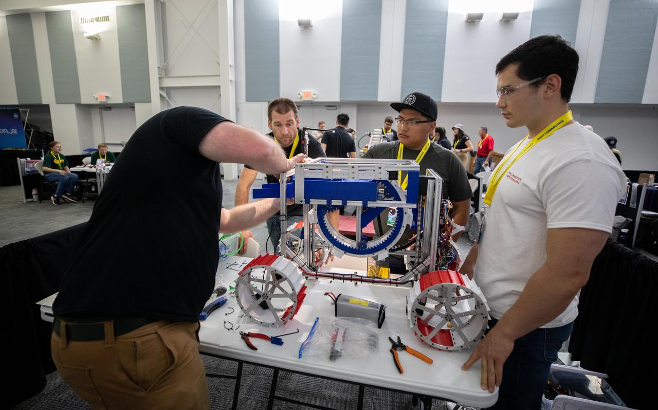 Team members from Sonoma State University in California prepare their robotic miner for its turn to dig in the mining arena during NASA’s LUNABOTICS competition on May 26, 2022, at the Center for Space Education near the Kennedy Space Center Visitor Complex in Florida. More than 35 teams from around the U.S. have designed and built remote-controlled robots for the mining competition. Teams use their semi-autonomous or remote-controlled robots to maneuver and dig in a supersized sandbox filled with rocks and simulated lunar soil, or regolith. The objective of the challenge is to see which team’s robot can collect and deposit the most rocky regolith within a specified amount of time. 