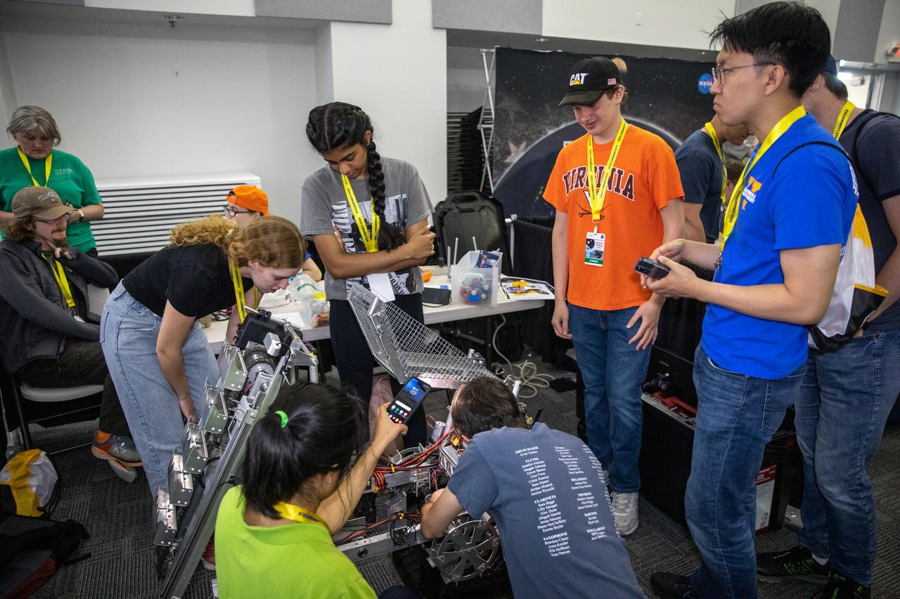 Students from the University of Virginia prepare their robotic miner for its turn to dig in the mining arena during NASA’s LUNABOTICS competition on May 26, 2022, at the Center for Space Education near the Kennedy Space Center Visitor Complex in Florida. More than 35 teams from around the U.S. have designed and built remote-controlled robots for the mining competition. Teams use their semi-autonomous or remote-controlled robots to maneuver and dig in a supersized sandbox filled with rocks and simulated lunar soil, or regolith. The objective of the challenge is to see which team’s robot can collect and deposit the most rocky regolith within a specified amount of time. 