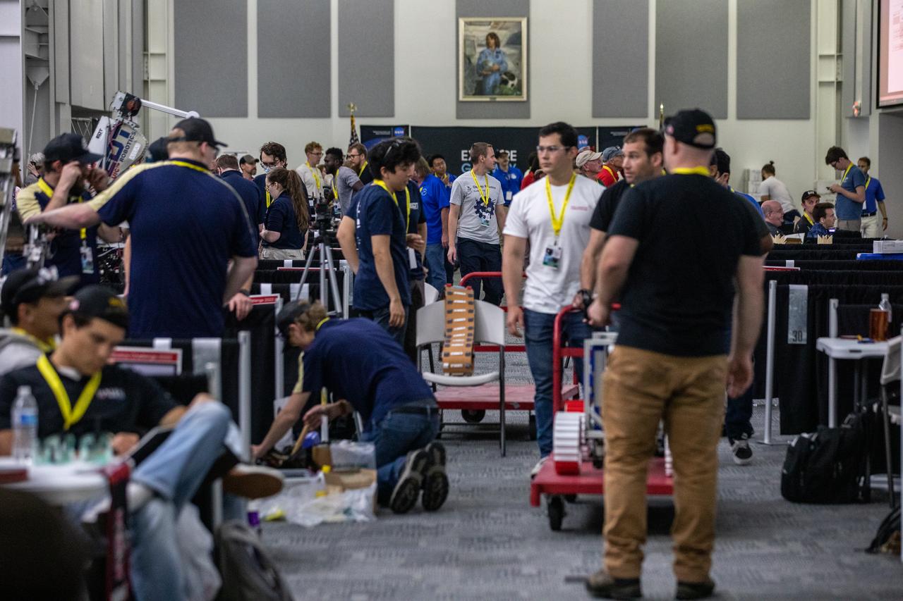 College teams prepare their robotic miners for their turn to dig in the mining arena during NASA’s LUNABOTICS competition on May 26, 2022, at the Center for Space Education near the Kennedy Space Center Visitor Complex in Florida. More than 35 teams from around the U.S. have designed and built remote-controlled robots for the mining competition. Teams use their semi-autonomous or remote-controlled robots to maneuver and dig in a supersized sandbox filled with rocks and simulated lunar soil, or regolith. The objective of the challenge is to see which team’s robot can collect and deposit the most rocky regolith within a specified amount of time. 