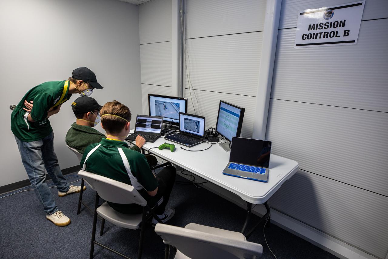 Team members from the College of DuPage in Illinois control their robotic miner in the mining arena during NASA’s LUNABOTICS competition on May 26, 2022, at the Center for Space Education near the Kennedy Space Center Visitor Complex in Florida. More than 35 teams from around the U.S. have designed and built remote-controlled robots for the mining competition. Teams use their semi-autonomous or remote-controlled robots to maneuver and dig in a supersized sandbox filled with rocks and simulated lunar soil, or regolith. The objective of the challenge is to see which team’s robot can collect and deposit the most rocky regolith within a specified amount of time. 