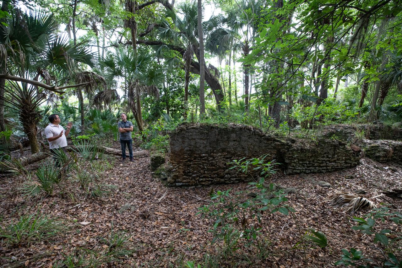 Members of U.S. Fish and Wildlife Service and NASA Communications visit the archeological ruins of the Elliot Plantation sugar mill at NASA’s Kennedy Space Center in Florida on May 26, 2022. The plantation’s enslaved community built the sugar mill structure, or sugar train, where sugar cane juice would be boiled during processing in graduated copper kettles until the liquid reduced into a thick syrup. The ruins of Elliot Plantation date from the 1760s and represent the largest, earliest, and southernmost British period sugar plantation in the U.S., as well as one of the most intact and best examples of a completely preserved enslaved landscape. The archeological site is managed through interagency cooperation between the National Park Service, the U.S. Fish and Wildlife Service, and NASA.