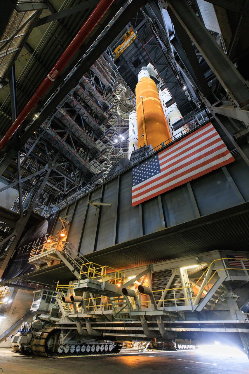 The crawler-transporter, driven by engineers, has moved underneath the Artemis I Space Launch System with the Orion spacecraft atop on the mobile launcher inside the Vehicle Assembly Building at NASA’s Kennedy Space Center in Florida on June 3, 2022. The crawler will carry the Artemis I stack to Launch Complex 39B for a wet dress rehearsal test ahead of the Artemis I launch. Artemis I will be the first integrated test of the SLS and Orion spacecraft. In later missions, NASA will land the first woman and the first person of color on the surface of the Moon, paving the way for a long-term lunar presence and serving as a steppingstone on the way to Mars.