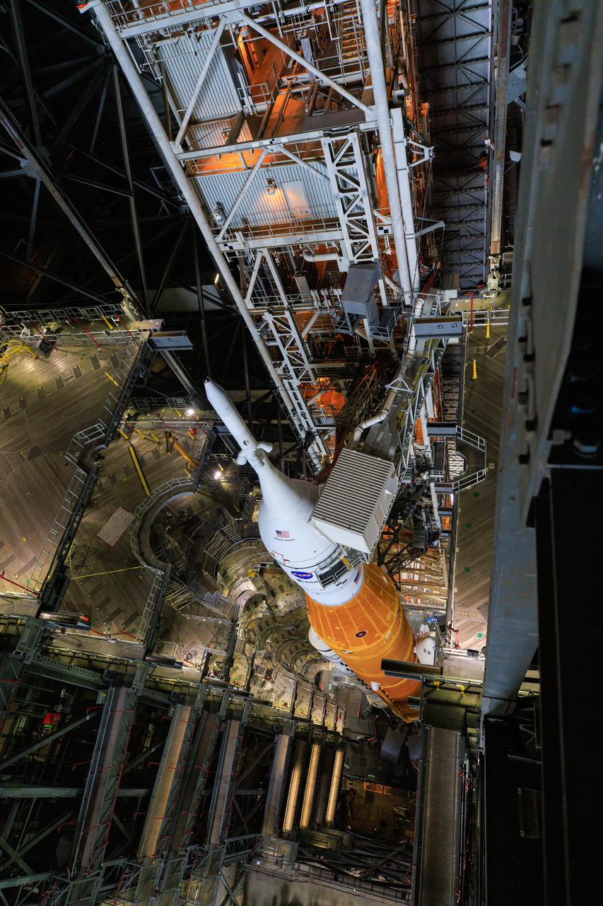 In this view looking down from high above in High Bay 3 of the Vehicle Assembly Building, the Artemis I Space Launch System and Orion spacecraft atop the mobile launcher is ready to move on the crawler-transporter to Launch Complex 39B at NASA’s Kennedy Space Center in Florida on June 3, 2022. The Artemis stack will be delivered to the pad for a wet dress rehearsal test ahead of the Artemis I launch. Artemis I will be the first integrated test of the SLS and Orion spacecraft. In later missions, NASA will land the first woman and the first person of color on the surface of the Moon, paving the way for a long-term lunar presence and serving as a steppingstone on the way to Mars.