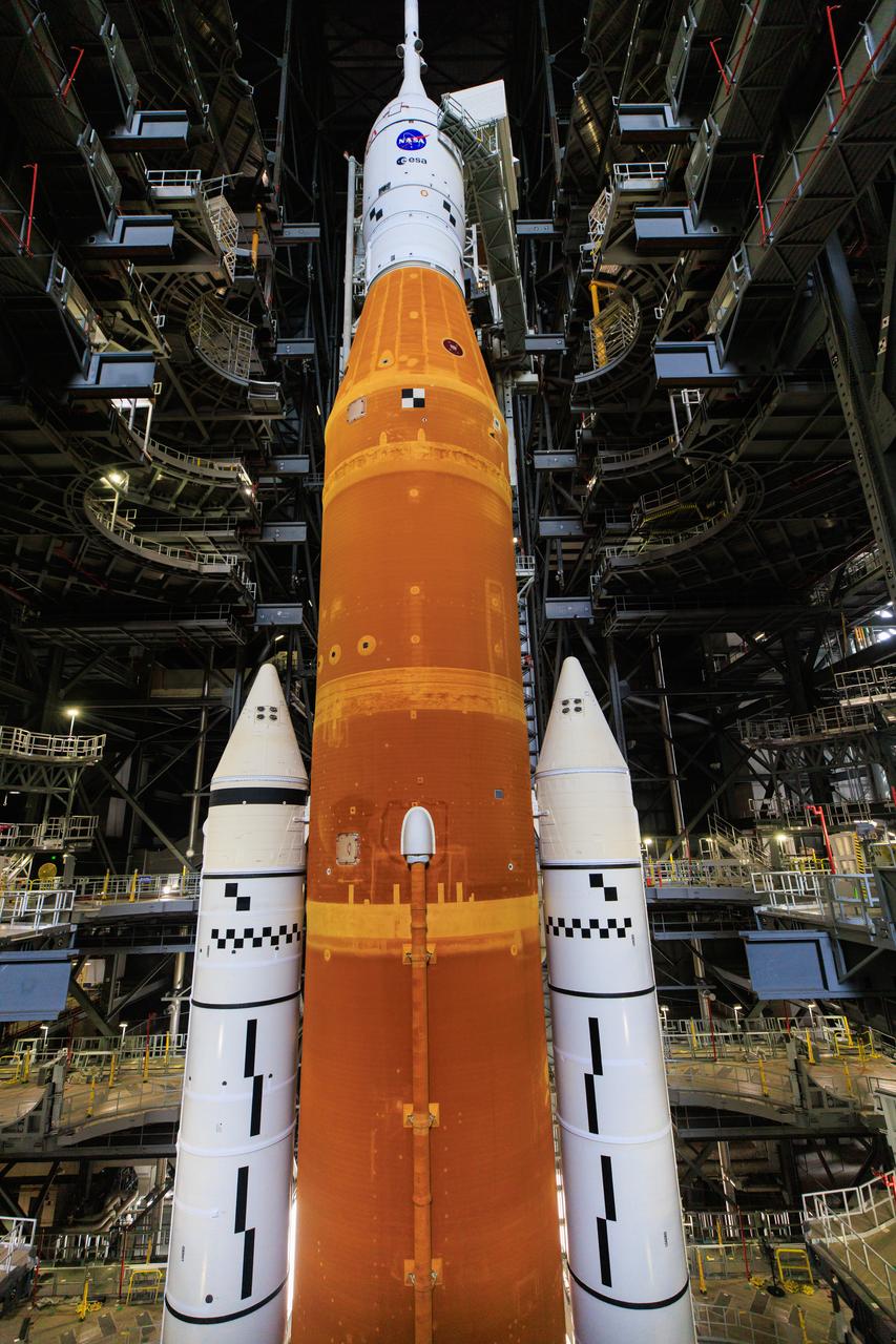 The Artemis I Space Launch System with the Orion spacecraft atop are in view inside High Bay 3 of the Vehicle Assembly Building at NASA’s Kennedy Space Center in Florida on June 3, 2022. The crawler-transporter, driven by engineers, is positioned underneath the Artemis I stack atop the mobile launcher. The crawler will carry the stack to Launch Complex 39B for a wet dress rehearsal test ahead of the Artemis I launch. Artemis I will be the first integrated test of the SLS and Orion spacecraft. In later missions, NASA will land the first woman and the first person of color on the surface of the Moon, paving the way for a long-term lunar presence and serving as a steppingstone on the way to Mars.