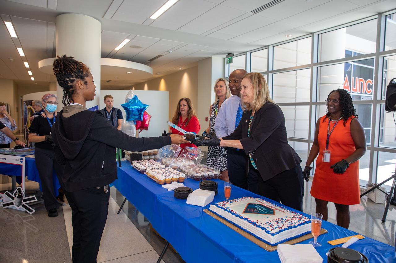 NASA Kennedy Space Center senior leaders helped celebrate the center’s 60th anniversary with a “Cheers to 60 Years” cake and non-alcoholic toast in the Central Campus Headquarters on June 28, 2022. Center Director Janet Petro hands a slice of cake to an employee. Also, from left are Nancy Bray, director of Spaceport Integration and Services; Kelvin Manning, deputy center director; and Hortense Blackwell, director of Communication and Public Engagement. In July 1962, the Launch Operations Center in Florida was established. By December 1963, it was renamed the John F. Kennedy Space Center.