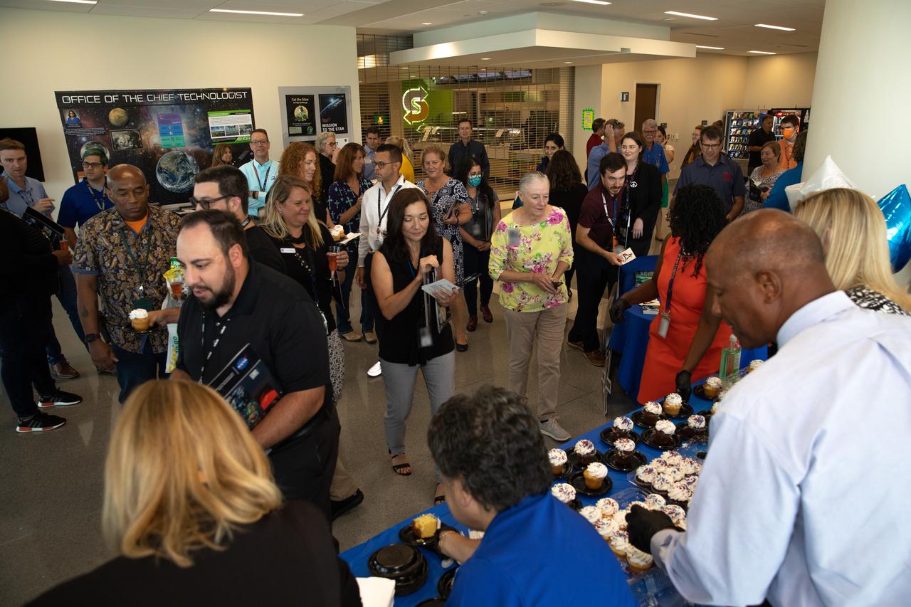 The NASA Kennedy Space Center senior leaders and employees celebrated the center’s 60th anniversary with a “Cheers to 60 Years” cake and non-alcoholic toast in the Central Campus Headquarters on June 28, 2022. From left, serving cake at the table, are Center Director Janet Petro; Janet Sellars, director of Human Resources; Kelvin Manning, deputy center director; and Nancy Bray, partially hidden, director of Spaceport Integration and Services. In July 1962, the Launch Operations Center in Florida was established. By December 1963, it was renamed the John F. Kennedy Space Center.