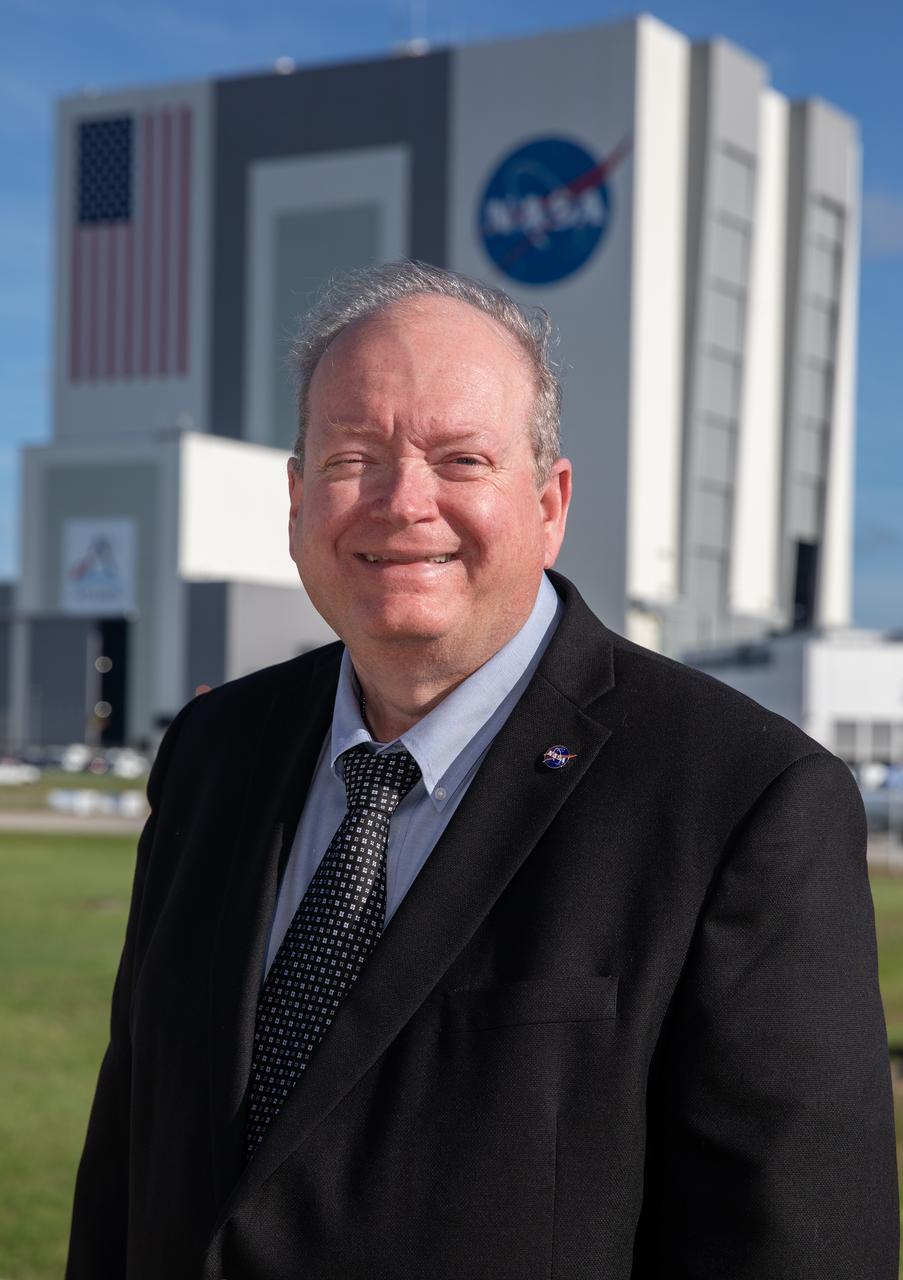 NASA Kennedy Space Center’s Associate Director of Management Burt Summerfield is shown with the Florida spaceport’s Vehicle Assembly Building in the background on June 29, 2022. Summerfield, who began his career at the center in 1982, is responsible for management of Kennedy’s Center Management and Operations (CMO) budget. His duties include executing the center’s strategic analysis, planning, business development, and communications capability that guide key center decisions and relationships.