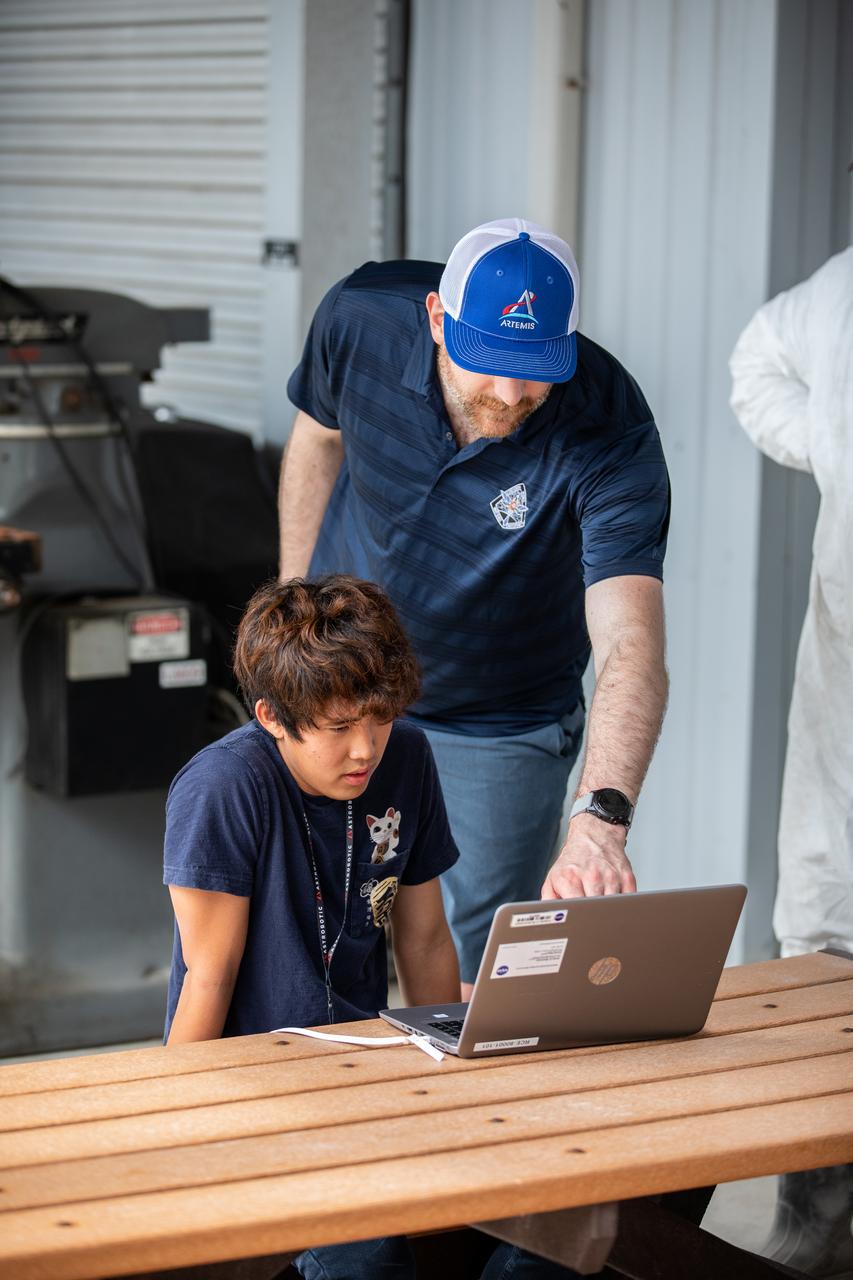 Robotics Software Engineer II Chris Rampolla (right) and Software Engineering intern Ashten Akemoto issue commands to Astrobotic’s CubeRover using the company’s ground software during mobility testing at NASA’s Kennedy Space Center in Florida on June 30, 2022. Astrobotic – a Pittsburgh-based space robotics company – is using the spaceport’s Swamp Works facility and the Granular Mechanics and Regolith Operations Laboratory to conduct mobility testing of their rover. The laboratory’s regolith bin, which holds approximately 120 tons of lunar regolith simulant, will help depict how the company’s CubeRover would perform on the Moon. NASA’s Small Business Innovation Research program provided the funding for initial development, and a $2 million Tipping Point award has provided additional funding for continued development into a more mature rover.