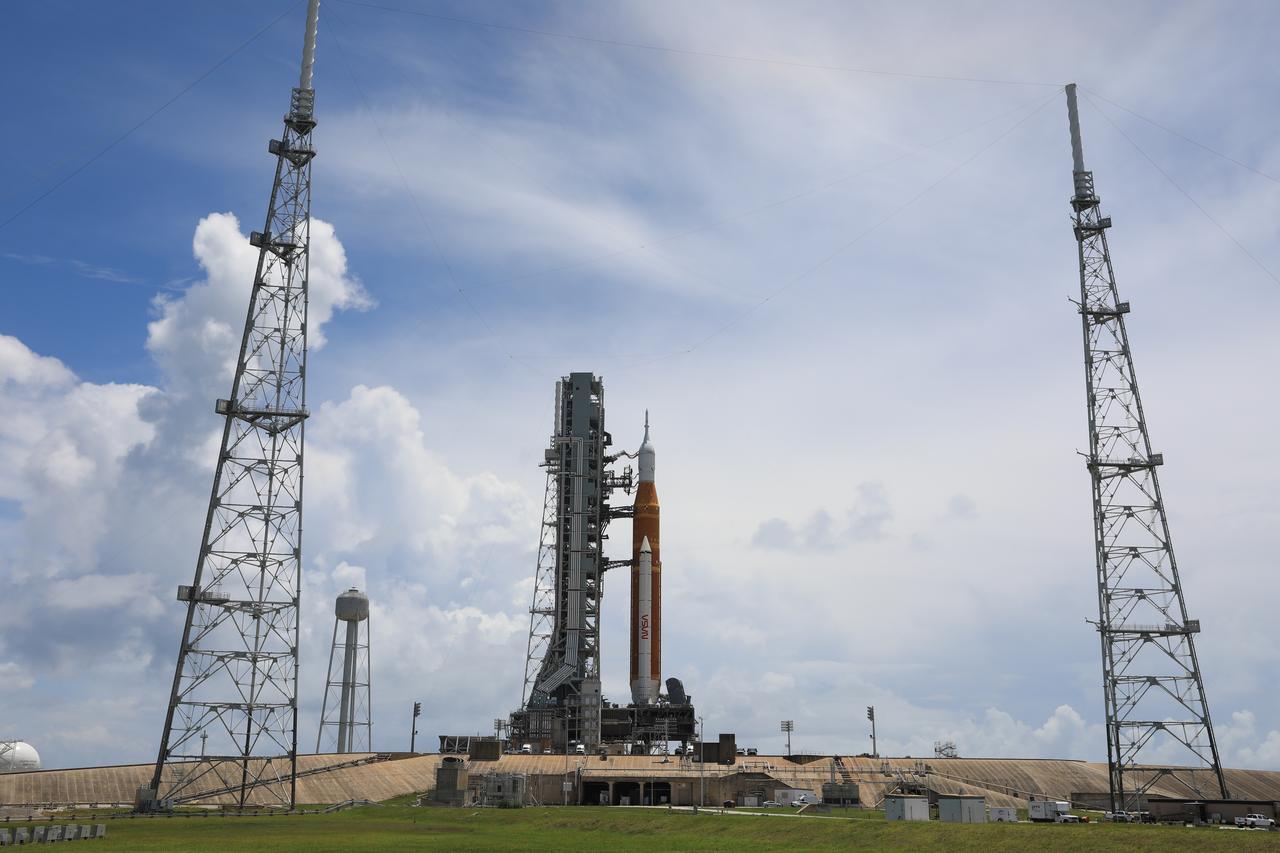 Blue sky and white clouds serve as a backdrop for the Artemis I Space Launch System (SLS) and Orion spacecraft atop the mobile launcher at Launch Pad 39B at NASA’s Kennedy Space Center in Florida on June 30, 2022. The SLS and Orion were transported to the pad on crawler-transporter 2 for a prelaunch test called a wet dress rehearsal. Artemis I will be the first integrated test of the SLS and Orion spacecraft. In later missions, NASA will land the first woman and the first person of color on the surface of the Moon, paving the way for a long-term lunar presence and serving as a steppingstone on the way to Mars. 