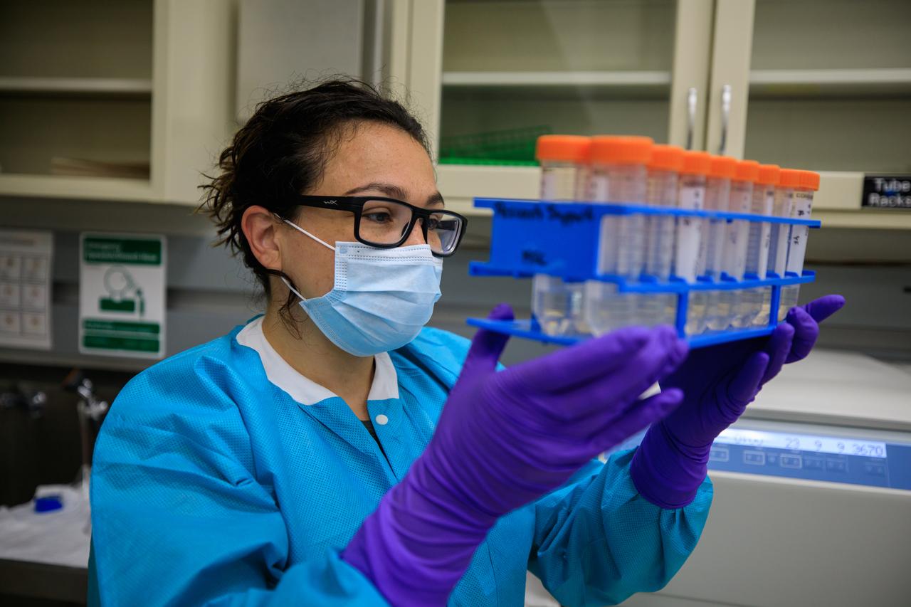 Marci Garcia, a research associate at Pacific Northwest National Laboratory (PNNL), examines some of the science tubes that make up the Dynamics of Microbiomes in Space (DynaMoS) experiment inside a laboratory at the Space Station Processing Facility on July 11, 2022. The DynaMoS experiment will launch on SpaceX’s 25th cargo resupply services mission to examine how microgravity affects metabolic interactions in communities of soil microbes. This will help NASA understand the function of soil microorganisms in space versus on Earth and how they can be used to enhance plant growth for crew consumption during long-duration missions to the Moon and Mars. SpaceX’s Falcon 9 rocket and Dragon spacecraft are scheduled to lift off from Kennedy’s Launch Complex 39A at 8:44 p.m. EDT on Thursday, July 14.