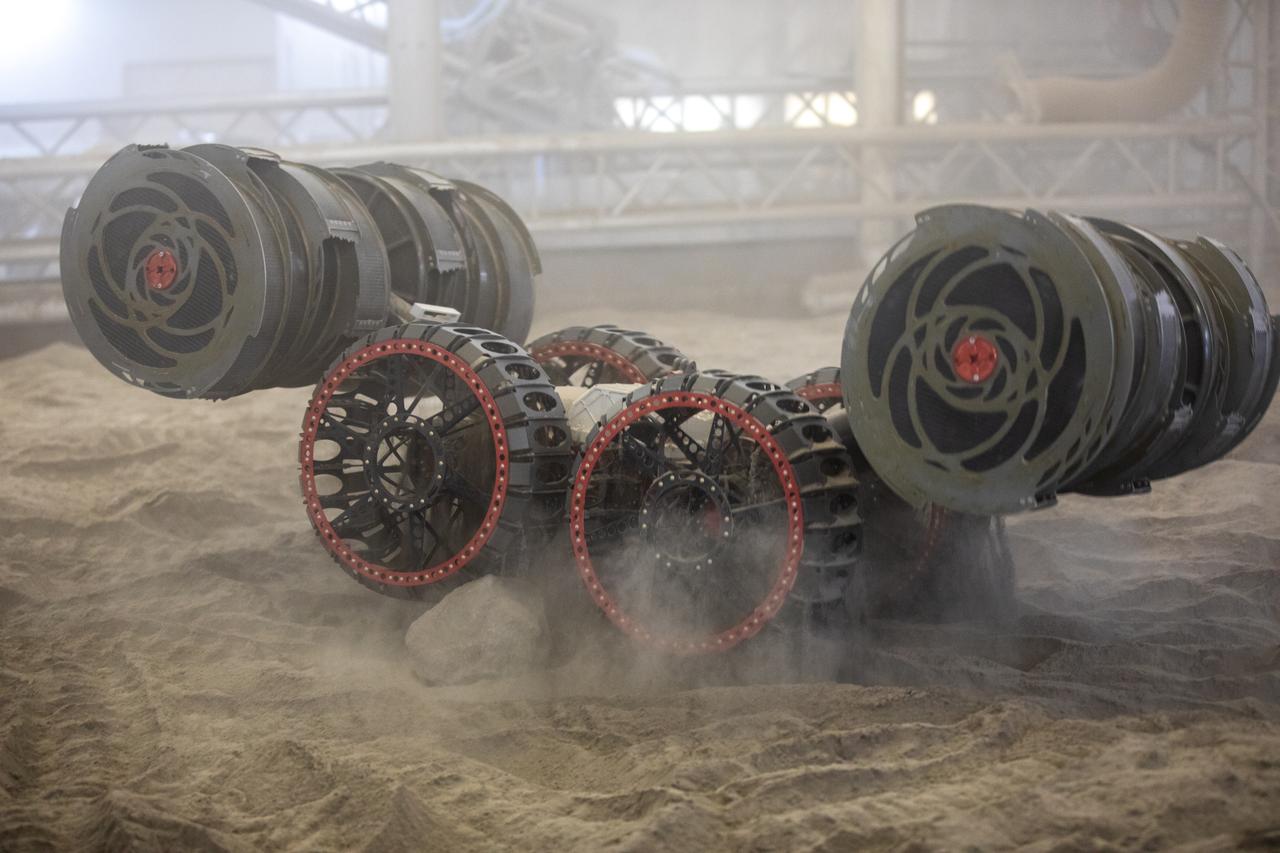 The ISRU Pilot Excavator digs in the regolith bin during testing inside Swamp Works at NASA’s Kennedy Space Center in Florida on July 28, 2022. Tests use a gravity assist offload system to simulate reduced gravity conditions found on the Moon. On the surface of the Moon, mining robots like the Pilot Excavator will excavate the regolith and take the material to a processing plant where usable elements such as hydrogen, oxygen and water can be extracted for life support systems. The Pilot Excavator can scoop up icy regolith which can be used to make operations on the Moon sustainable.