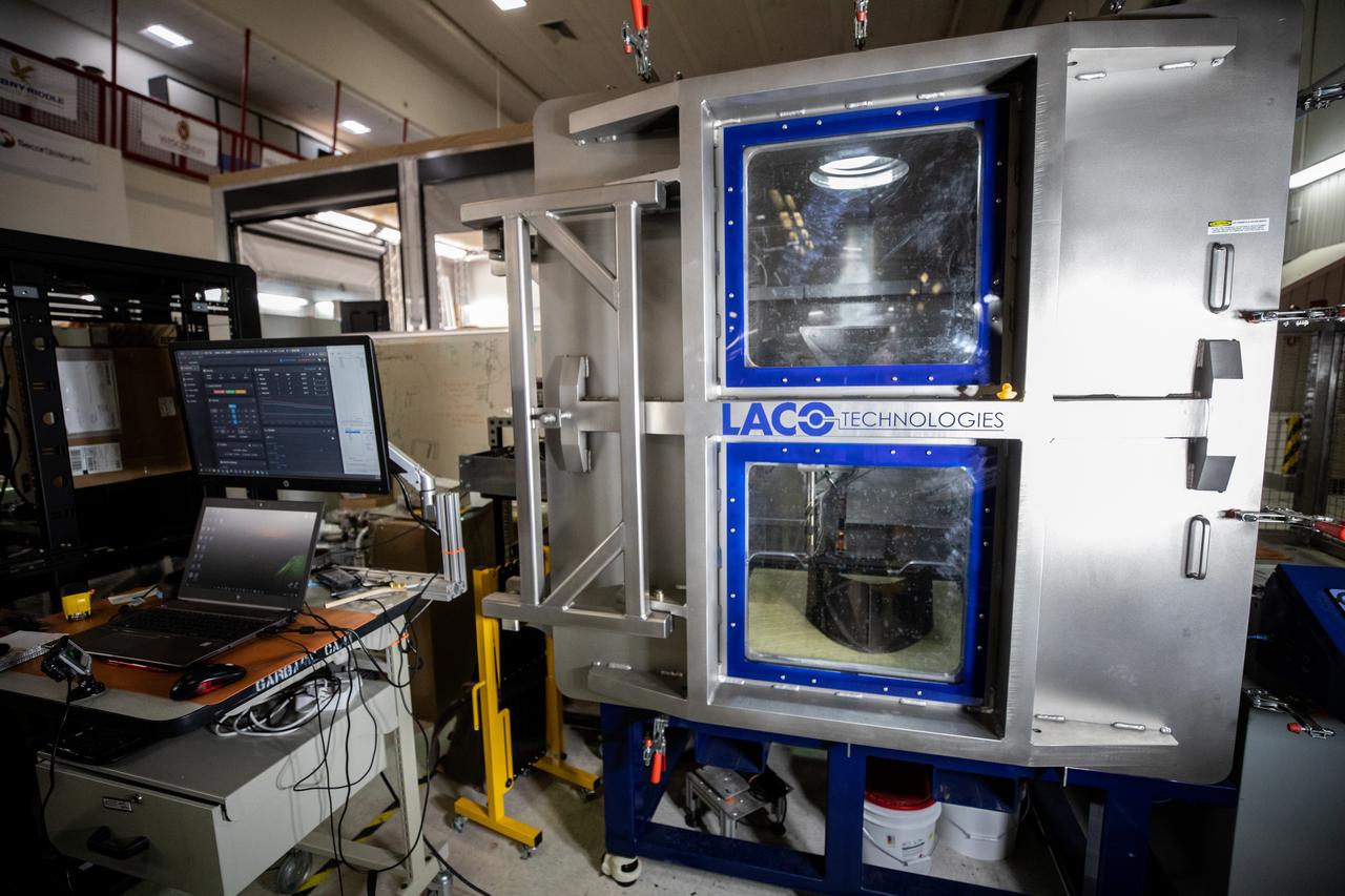 A team at NASA’s Kennedy Space Center in Florida tests a 3D printer on July 28, 2022, at the Florida spaceport’s Swamp Works, as part of the Relevant Environment Additive Construction Technology (REACT) project. Among the key objectives of the project is developing an architectural and structural design for a shelter that provides protection to habitable assets on the lunar surface. Testing REACT derives from NASA’s 2020 Announcement of Collaboration Opportunity with AI SpaceFactory – an architectural and construction technology company and winner of NASA’s 3D Printed Habitat Challenge.