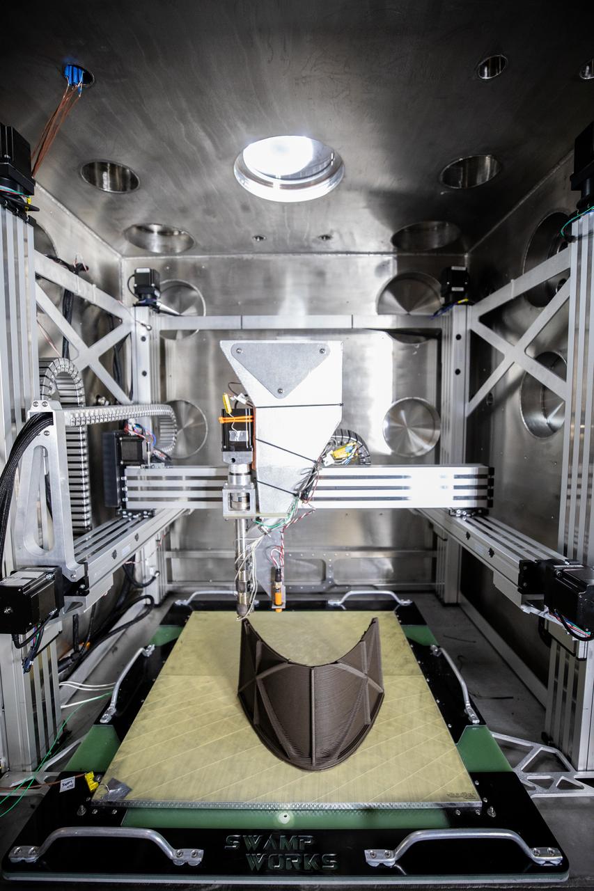 A team at NASA’s Kennedy Space Center in Florida tests a 3D printer on July 28, 2022, at the Florida spaceport’s Swamp Works, as part of the Relevant Environment Additive Construction Technology (REACT) project. Among the key objectives of the project is developing an architectural and structural design for a shelter that provides protection to habitable assets on the lunar surface. Testing REACT derives from NASA’s 2020 Announcement of Collaboration Opportunity with AI SpaceFactory – an architectural and construction technology company and winner of NASA’s 3D Printed Habitat Challenge.